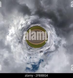 tiny planet in blue sky with beautiful clouds. Transformation of spherical panorama 360 degrees. Spherical abstract aerial view. Curvature of space. Stock Photo