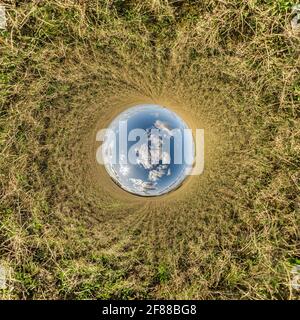 blue sky ball in middle of swirling field. Inversion of tiny planet transformation of spherical panorama 360 degrees. Curvature of space. Stock Photo