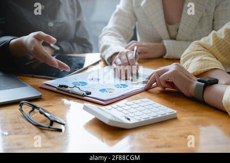 Asian Fund managers team consultation and discuss about analysis Investment stock market by financial document paper. Stock Photo