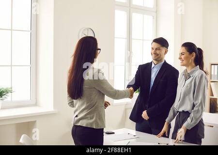 Couple and woman financial advisor sealing with handshake thanking for advice Stock Photo