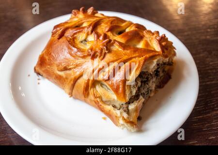 Traditional Russian sliced pie Kurnik close up on a slate board on the  table. vertical Stock Photo - Alamy