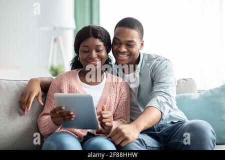 Relaxed african american family using digital tablet together Stock Photo