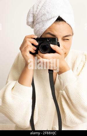 a woman taking a photo with his camera and a towel on her head Stock Photo