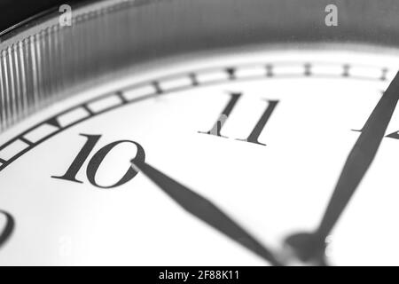 Clock hand pointing ten o'clock on white clock face of Twin bell classic alarm clock Stock Photo