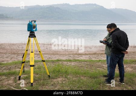 (210412) -- ZHONGXIAN, April 12, 2021 (Xinhua) -- Researchers collect landscape data in Zhongxian County, southwest China's Chongqing, April 10, 2021. The Three Gorges project is a vast multi-functional water-control system on the Yangtze River, China's longest waterway, with a 2,309-meter-long and 185-meter-high dam.The water levels of the reservoir area inevitably fluctuate on an annual discharge-storage cycle between 145m to 175m at the dam. The water level fluctuation zone also encounters some eco-environmental problems, including soil erosion and non-point source pollution. Researchers of Stock Photo