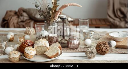 Freshly baked homemade cakes on a festive Easter table. Home serving hygge style. Stock Photo