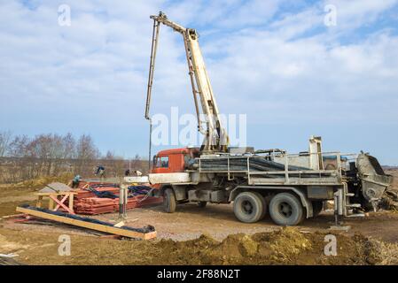 LENINGRAD REGION, RUSSIA - MARCH 28, 2021: A concrete pump based on a Kamaz truck on the construction site of a country house on a sunny spring day Stock Photo