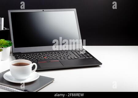 Modern minimal workplace for man with copy space. Home Office laptop screen blank display workspace. Desktop with laptop pc smart phone, office Stock Photo
