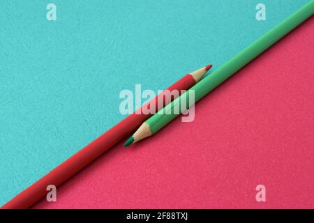 Two colored pencils split a picture in half in two different colors. Free space for text Stock Photo