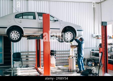 Car lifted on car lift for routine maintenance Stock Photo - Alamy