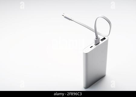 Powerbank for charging mobile devices with cable, on a white background. Universal external battery for gadgets. Isolate Stock Photo