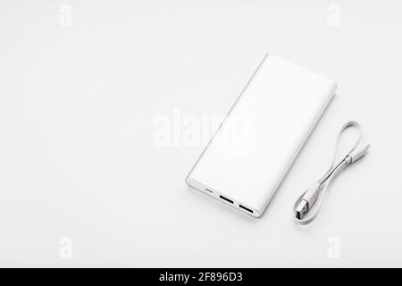 Powerbank for charging mobile devices with cable, on a white background. Universal external battery for gadgets. Isolate Stock Photo