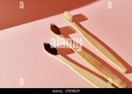 Eco friendly bamboo toothbrushes on pink background. Flat lay top view. Stock Photo