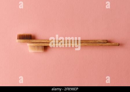 Two eco friendly bamboo toothbrushes on pink background. Flat lay top view. Stock Photo