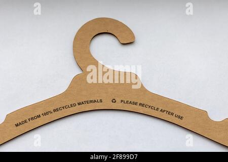 A portrait of a recyclable clothes hanger made of paper and cardboard lying on a white background with the recycle instructions on it. This is an envi Stock Photo