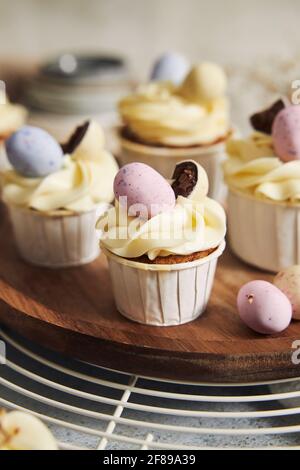 Delicious carrot cupcakes with whipped cream and topping from candies in eggs shape for Easter Stock Photo