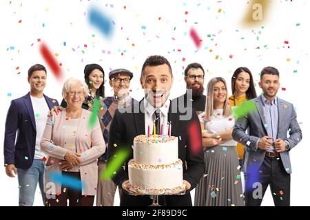 Young man with a birthday cake celebrating with people around isolated on white background Stock Photo