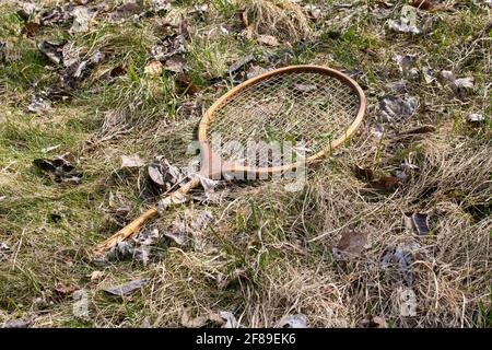 Old broken badminton racket in the grass close up Stock Photo