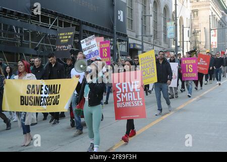 Vancouver, British Columbia, Canada. 10th Apr, 2021. Several hundred mostly small business owners, employees and supporters march through downtown Vancouver British Columbia (BC) on April 10, 2021, during the Save Small Business Rally to protest against COVID-19 renewed lockdowns imposed by BC Provincial Health Officer Dr. Bonnie Henry. Government liquor stores and large corporation box stores seem to receive more favorable operating rules compared to small business. Heinz Ruckemann/ZUMA Press Credit: Heinz Ruckemann/ZUMA Wire/Alamy Live News Stock Photo