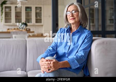 Mature smiling 60s woman portrait at home looking at camera. Stock Photo
