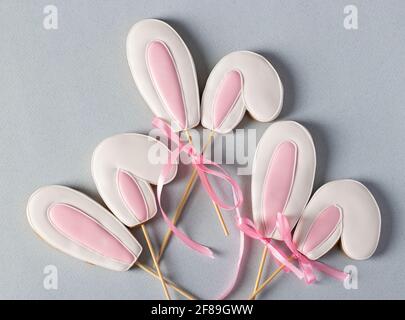 Gingerbread cookies in the shape of bunny ears on a pastel blue background. View from above. Close-up Stock Photo