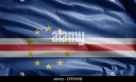 Cape Verdean flag waving in the wind. Close up of Cape Verde banner blowing, soft and smooth silk. Cloth fabric texture ensign background. Stock Photo