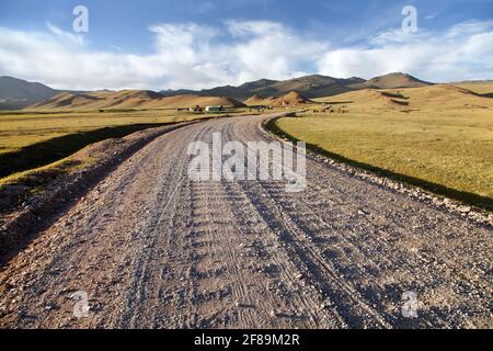 Unpaved road and yurts near Son-Kul lake and Tian Shan mountains in Kyrgyzstan Stock Photo