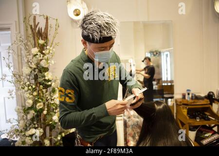 London, UK. 12th Apr, 2021. A hairdresser wearing a face mask cuts hair of a client during the reopening. Shops, restaurants, bars and other businesses reopened today after almost four months as further lockdown rules are relaxed in England. (Photo by Yunus Dalgic/SOPA Images/Sipa USA) Credit: Sipa USA/Alamy Live News Stock Photo