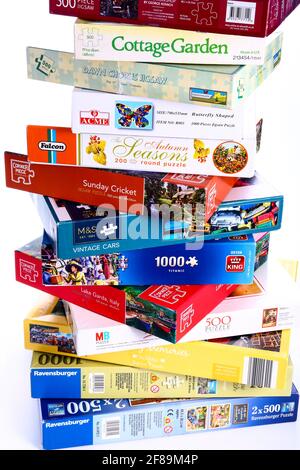 Stack of jigsaw puzzle boxes waiting to be solved Stock Photo