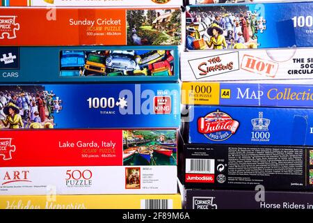 Stack of jigsaw puzzle boxes waiting to be solved Stock Photo