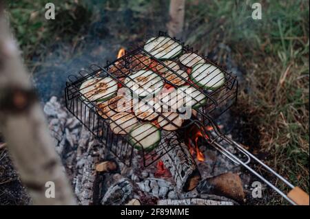 Couple in a checkered plaid roasting marshmallows on fire near the trailer home. Stock Photo