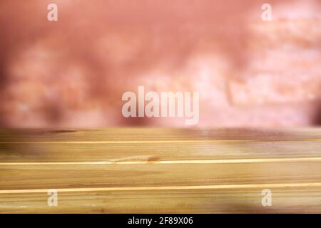 Rustic light brown wooden empty table top against red blurry brick wall background, can be used to display products. Stock Photo