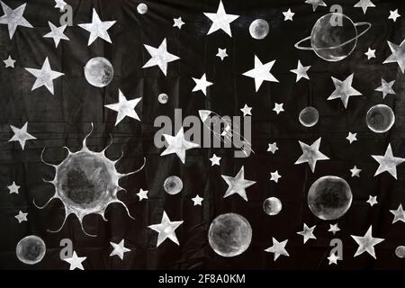 a black cloth background decorated with children's drawings of stars, planets and a funny space rocket, background with space and solar system themes, Stock Photo