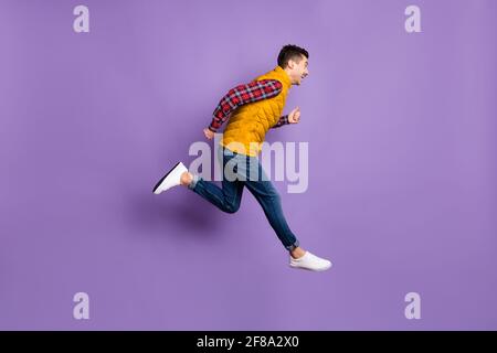 Full size profile photo of optimistic guy run wear shirt jeans vest isolated on violet background Stock Photo