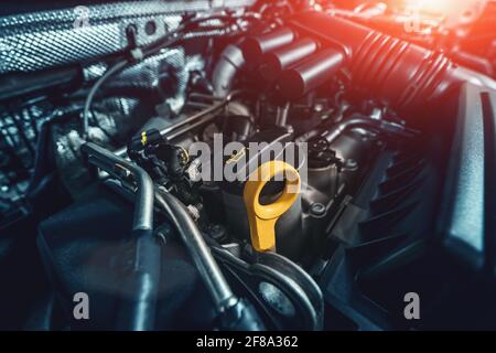 Engine compartment under car hood with emphasis on oil dipstick. Control, check and change oil concept. Stock Photo