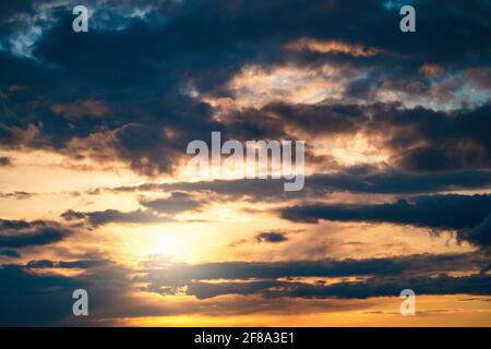 Dramatic sunset cloudy sky with blue clouds as abstract beautiful cloudscape background. Stock Photo