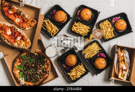 Lockdown fast food dinner with burgers, beer, pizza Stock Photo