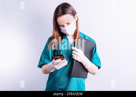 doctor sending message to patient with mobile phone holding a report and pen. contact telephonic care at a distance Stock Photo