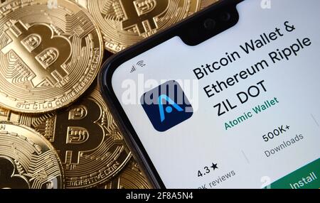 Bitcoin Wallet & Ethereum Ripple ZIL DOT app seen on the smartphone screen placed on top bitcoin coins pile. Concept. Stafford, United Kingdom, April Stock Photo