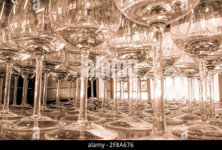 Low angle shot of tall, clear wine glasses arranged in rows Stock Photo