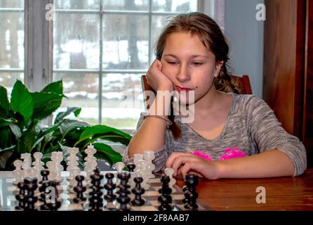 Young girl taking time to figure out her next chess move Stock Photo