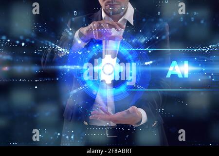 Business, Technology, Internet and network concept. Young businessman working on a virtual screen of the future and sees the inscription: AI Stock Photo