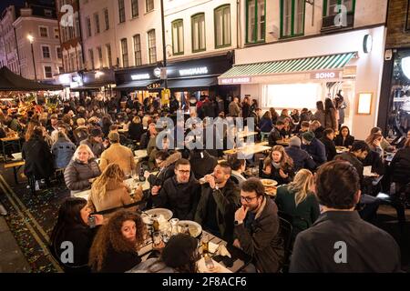 London, UK. 13 April 2021. People gather in Soho, London, where streets were closed to traffic as bars and restaurants opened for outside eating and drinking, as lockdown measures are eased across the UK. Picture date: Tuesday April 13, 2021. Photo credit should read: Matt Crossick/Empics/Alamy Live News Stock Photo