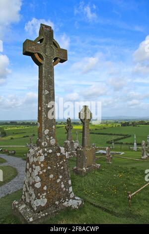 Mossy Stone Celtic Crosses or Cross Against Bright Blue Sky and Green Grass in Ireland Stock Photo