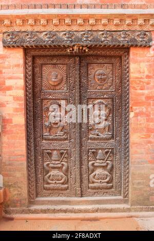 Carved wooden door in brick building in Bhaktapur, Nepal Stock Photo
