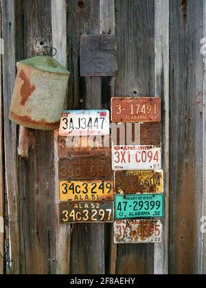 Old, vintage antique Alabama license plates nailed to the side of an old cabin in rural Alabama, USA. Stock Photo