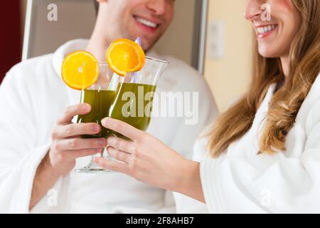 Young couple - man and woman - drinking Chlorophyll-Shake in spa Stock Photo