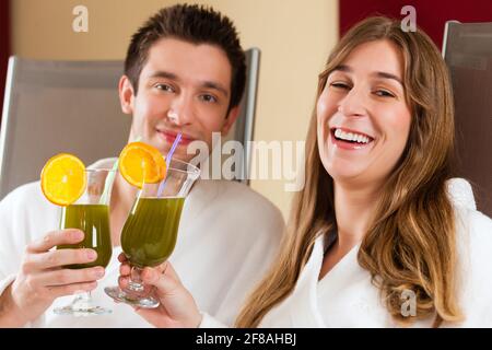 Young couple - man and woman - drinking Chlorophyll-Shake in spa Stock Photo