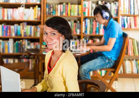 Students write in library learning on the Laptop - Portrait of a female student Stock Photo