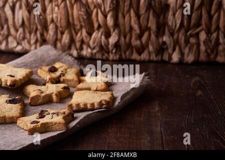 Healthy homemade gluten-free, lactose-free cookies of various shapes without sugar with raisins and chocolate on a dark brown wooden background Stock Photo